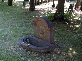 Kein Grabstein sondern ein altes Waschbecken aus dem ehemaligen Trauerhaus